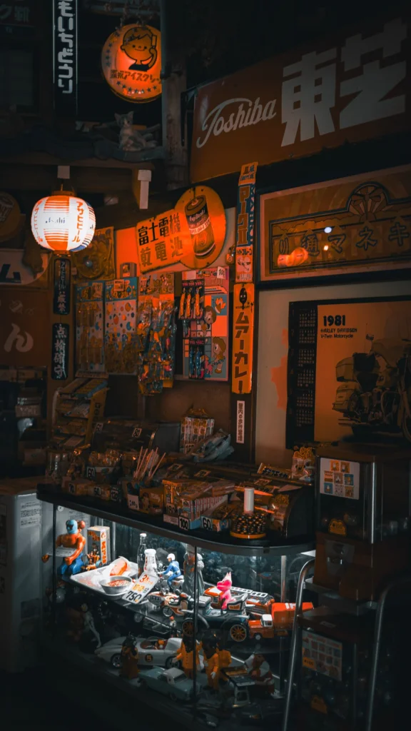 Vitrine rétro éclairée aux enseignes publicitaires anciennes et lanternes orange dans un musée japonais