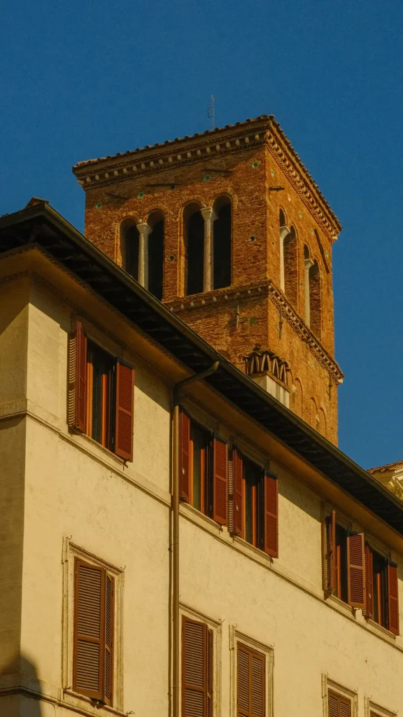 Vue en contre-plongée du campanile en brique du XIIe siècle de la basilique Santi Giovanni e Paolo, orné de disques de céramique et de baies à colonnettes