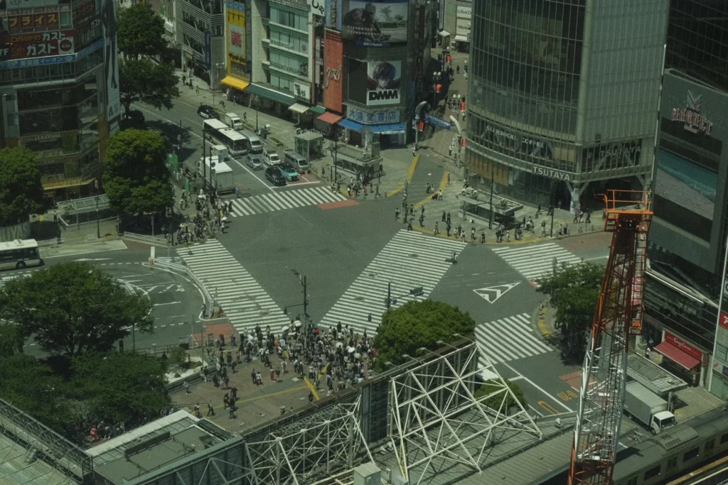 Vue en hauteur du carrefour de Shibuya avec la foule traversant entre les écrans lumineux, Tokyo