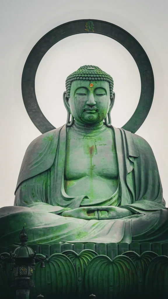 Statue du grand Bouddha de bronze à la patine verte, avec auréole et socle en lotus