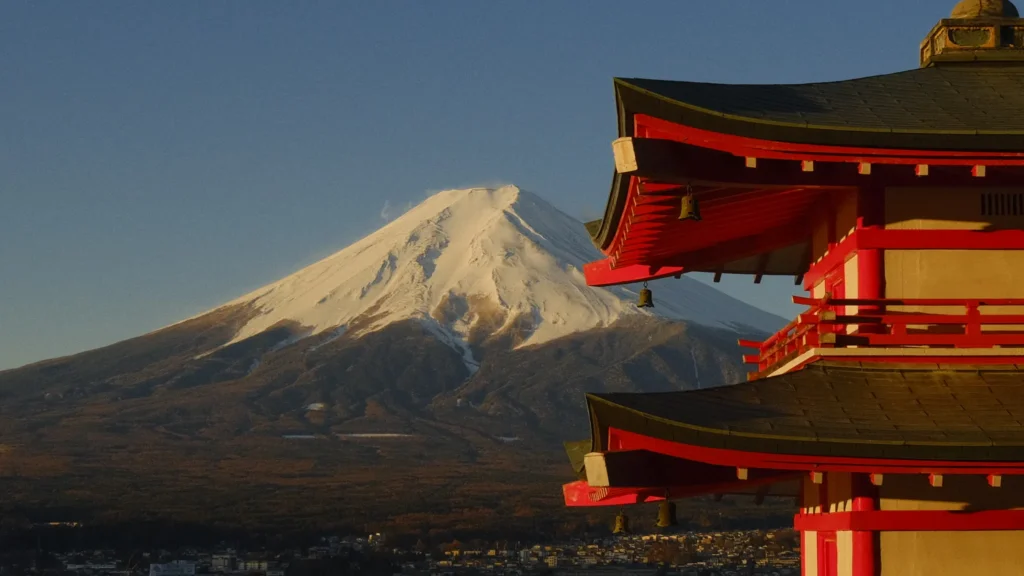 Toits rouges d'une pagode japonaise avec le mont Fuji enneigé en arrière-plan à Fujiyoshida