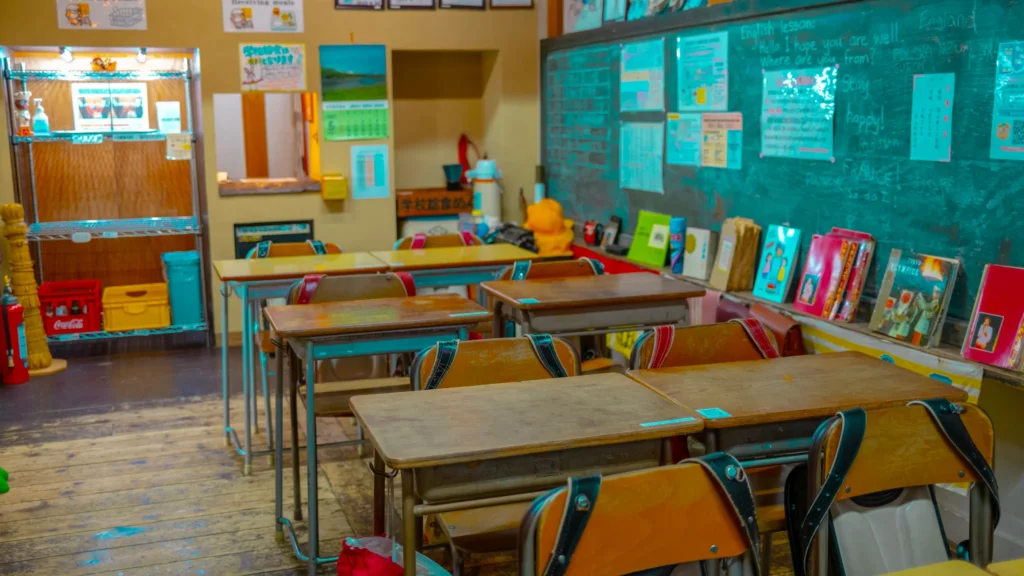 Salle de classe rétro de l'ère Shōwa avec pupitres en bois, cartables et tableau vert, dans un musée japonais